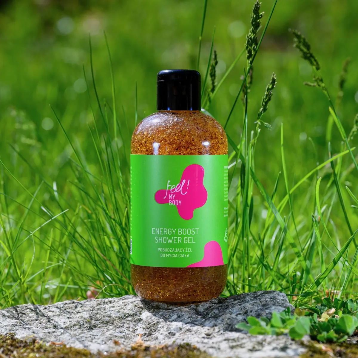 Żel pod prysznic Energy Boost na kamieniu w wysokiej trawie